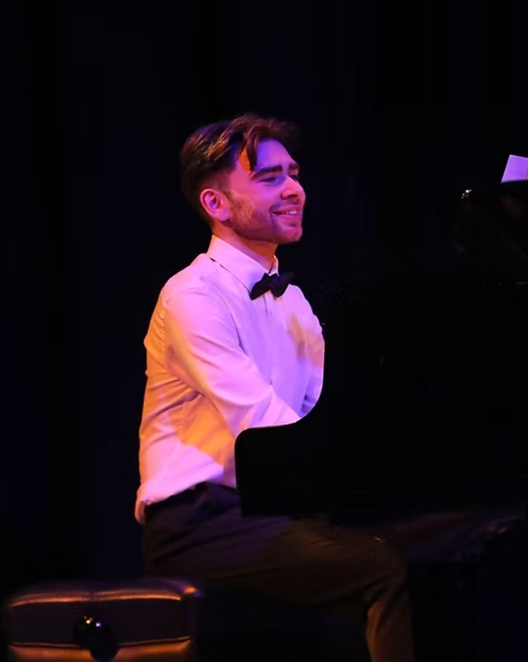 Lorcan Cleary playing a grand piano on stage